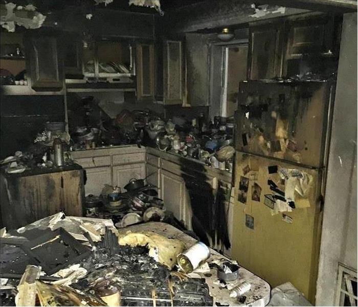 Kitchen filled with trash and fire damaged contents
