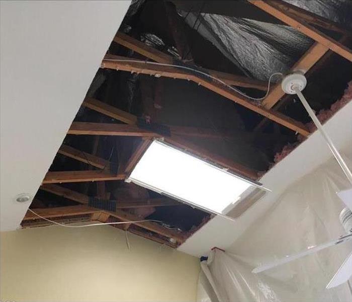 Ceiling with drywall removed covered in black plastic