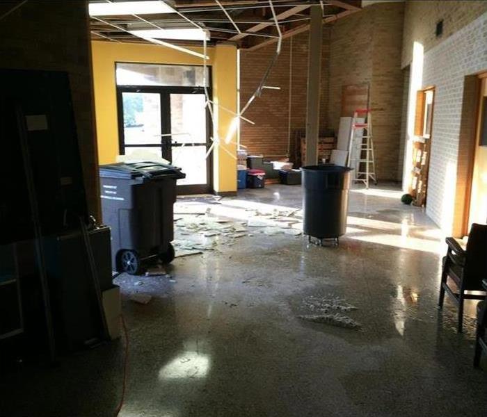 Commercial building with fallen ceiling and water on vinyl floors