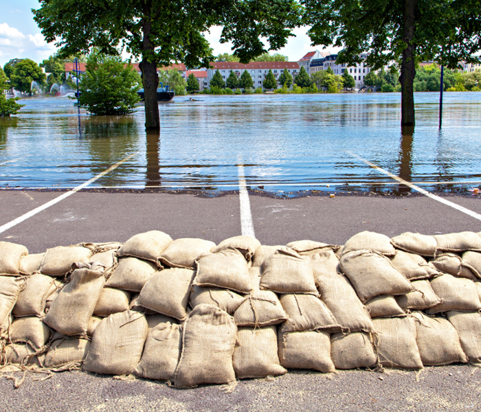 Sandbags stacked in parking lot to hold back rising water.